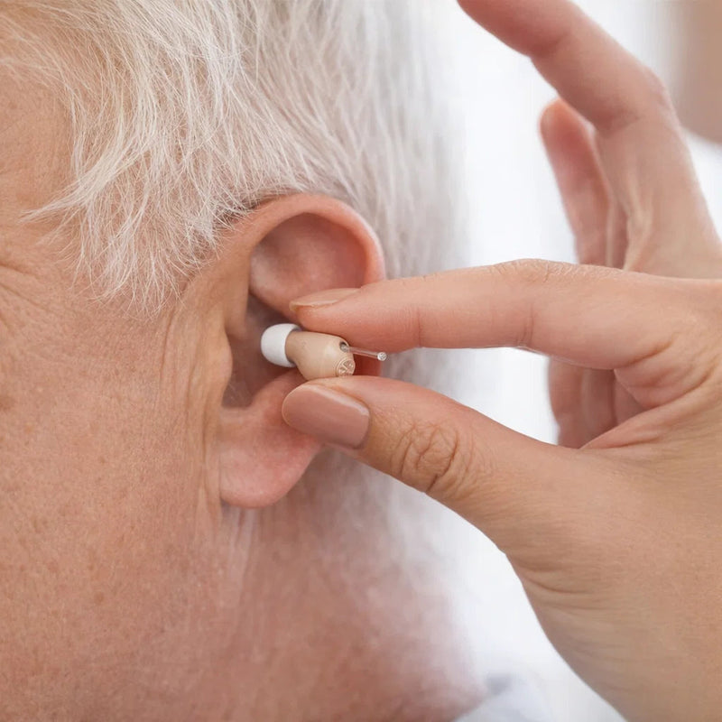 Person inserting a discreet hearing aid